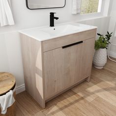 a bathroom with a sink, mirror and wood flooring in the room that has white walls