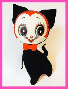 a black and white cat stuffed animal with big eyes