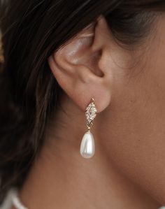 a close up of a person wearing some kind of earring with pearls on it