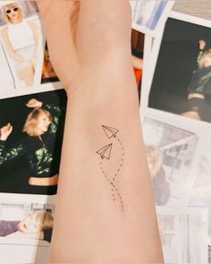 a woman's arm with a small airplane tattoo on the left side of her arm