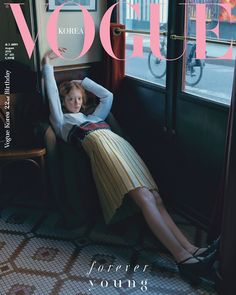 a woman sitting in a chair on the cover of a magazine with her legs crossed