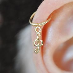 a close up of a person's ear with a ring on it