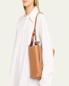 Tod's bucket bag in grained calf leather     Fixed top handles, 12.6" drop     Hook closure     Removable pendant with branded metal T Timeless accessory    Interior, two slip pockets     Lining: Leather/nylon/polyurethane    Approx. 12.6"W x H 11.8"H x 4.7"D    Made in Italy Calf Leather Bucket Bag With Gold-tone Hardware For Workwear, Calf Leather Bucket Bag With Leather Handles For Work, Calf Leather Bucket Bag With Detachable Handle For Work, Calf Leather Bucket Bag For Work, Calf Leather Bucket Shoulder Bag For Work, Modern Calf Leather Bucket Bag For Business, Timeless Tan Shoulder Bag For Work, Calf Leather Bucket Bag With Double Handle For Work, Tan Bucket Bag With Detachable Handle