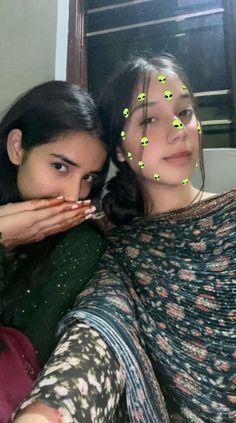 two women are posing for the camera with their hands on their faces and fingers pointing at them