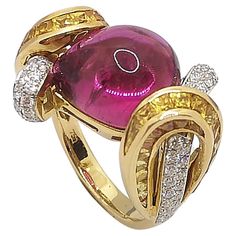 Cabochon Pink Tourmaline 11.94 carats with Diamond 0.69 carat and Yellow Sapphire 5.29 carats Ring set in 18 Karat Gold Settings Width: 2.3 cm Length: 1.5 cm Ring Size: 54 Total Weight: 12.1 grams "We first opened doors in 1980 when it was then situated in the vicinity of the Victory Monument; a small and modest storefront with a couple of counters. From its humble beginnings to where it stands today, our company has proven its abilities as a jeweler. Since the beginning, we have been supplying Luxury Fine Jewelry Ruby Ring With Cabochon, Luxury Pink Cabochon Ring, Luxury Diamond Cabochon Gemstones, Luxury Diamond Gemstones With Cabochon Cut, Luxury Oval Cabochon Gemstones, Luxury Domed Cabochons For Formal Occasions, Luxury Yellow Gold Oval Cabochon Gemstones, Yellow Gold Diamond Cabochons Fine Jewelry, Luxury Yellow Gold Gemstone Cabochon