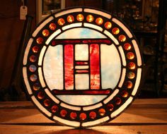 a stained glass window with the letter h in it