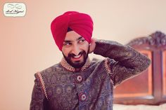 a man wearing a red turban is posing for the camera