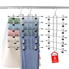 clothes hangers are hanging on the wall with six pairs of pants in front of them