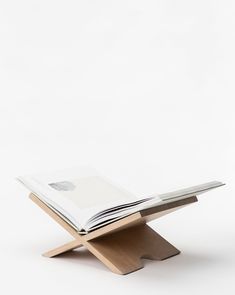 an open book sitting on top of a wooden stand