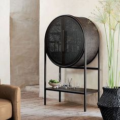 a living room with two chairs and a large round shelf next to a potted plant