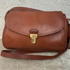 Vintage Coach Gilford Bag - British Tan In Color. Excellent Condition. Leather Is Soft, Conditioned And Free From Tears, Holes. Interior Flap Has A Few Pin Marks, Please See Picture. Overall, This Bag Is Beautiful For Its Age. Brass Touchlock Closure Slip Pockets Exterior Backside, Interior Zipper Pocket And Pocket Under Flap In Front Of Bag. 10.25”W X 7”H X 4”D Strap Drop 48” Classic Camera Bag Satchel With Detachable Strap, Classic Bags With Detachable Strap For Errands, Vintage Bags With Leather Lining For On-the-go, Vintage Bag With Leather Lining For On-the-go, Classic Cognac Shoulder Bag For Errands, Vintage Coach Shoulder Bag For Travel, Vintage Coach Satchel For Daily Use, Classic Flap Tote Bag For On-the-go, Classic Tote Flap Bag For On-the-go