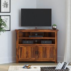 a flat screen tv sitting on top of a wooden entertainment center in a living room