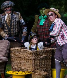 three people dressed in costumes standing next to each other with baskets on the ground near them