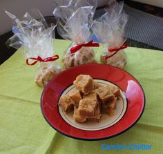 three bags of caramel fudges on a red plate next to some candy