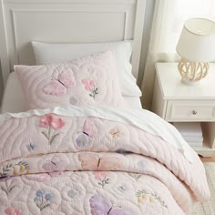 a bed with pink and white quilted bedspreads