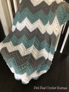 a crocheted blanket sitting on top of a wooden floor