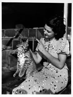 an old photo of a woman holding a cat