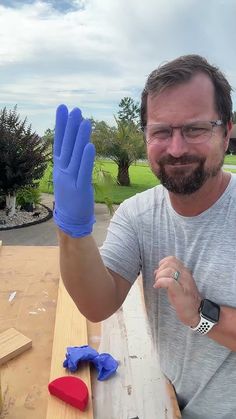 a man wearing blue gloves is holding up his hand