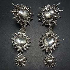 GREGORY SEGURA SOUTHWEST SANTA FE ARTISAN STERLING SILVER  EARRINGS DESCRIPTION:  A triple tier dangle of graduating solid sterling silver hearts... Santa Rosa sacred Heart, the Mesilla Burning heart and the Taos Sacred Heart. These magnificent earrings by celebrated Santa Fe silversmith Gregory Segura will be a cherished addition to your collection of quality Southwestern and Native American jewelry. MEASUREMENTS: Earrings measure 2 3/4"  x  1 1/4" WEIGHT:  25.9 grams SIGNED:  Gregory Segura  S Charm Ideas, Jewelry Measurements, Burning Heart, Sterling Silver Heart Earrings, Cowgirl Jewelry, Silver Heart Earrings, Modernist Jewelry, Dope Jewelry, Silver Dangle Earrings