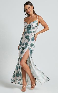 Get ready to turn heads in the stunning Kenna Maxi Dress - Cowl Neck Thigh Split Slip Dress In Keepsake Floral. This white formal dress is the epitome of elegance, with its backless design and flattering cowl neck. Made from luxurious satin polyester, this maxi dress will make you feel like a true goddess wherever you go. The thigh-high split adds a touch of allure, while the beautiful keepsake floral print adds a romantic and feminine touch. Whether you're attending a wedding or hitting the dan Elegant Spring Gown With Corset Back, Prom Maxi Dress With Bias Cut, Bias Cut Maxi Length Prom Dress, White Satin Backless Dress For Party, White Satin Backless Party Dress, Fitted Low Back Bias Cut Dress, Elegant Low Back Dress With Tie Detail, Elegant Dresses With Tie Back And Low Back, Prom Dress With Tie Back Long Shape