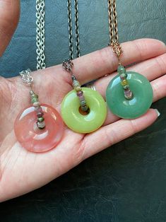 "Another CrackedHaloDesign Original. Gemstone donuts have been lovingly wrapped with high grade faceted rainbow tourmaline beads for a bit of luxurious whimsy. Each circle pendant has its own individual unique beauty created by Mother Nature. These are reversible and may be used as fidget toys or spinners, as each gem moves freely within the wrap. These three are so juicy and exude all the summer vibes! Unique and beautiful to wear everyday. Select your exact pendant and choice of necklace lengt Gemstone Donut Necklace, Crystal Donut Necklace, Wire Wrapped Round Agate Jewelry, Bohemian Tourmaline Round Beads Jewelry, Bohemian Tourmaline Bead Jewelry, Pink Jade Jewelry With Natural Stones, Sterling Silver Crystal Necklace With Gemstone Beads, Handmade Pink Crystal Necklaces, Handmade Jade Rondelle Jewelry