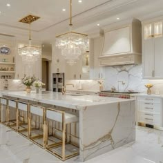 a large kitchen with marble counter tops and gold trimming on the ceiling, along with white cabinets