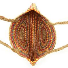 a multicolored basket hanging from a rope on a white wall with an opening