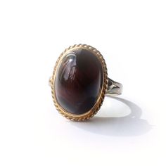 A beautiful vintage Tiger's Eye ring. This unique vintage ring features a large ploished Tiger's Eye cabochon set in a wonderful high profile solid silver gilt setting. The striking Tiger's Eye has a captivating depth and warmth to the gemstone, it is not easy to capture it's magic i a photograph.  A simply gorgeous vintage ring!  This ring comes with our very own Milly's Marvels gift box hand tied with Ribbon This ring is sizeable SIZE - US Size 6 3/4 / UK O WEIGHT - 4.4grams ERA - Circa 1970s Vintage Oval Cabochons For Formal Occasions, Vintage Gemstone Cabochons For Anniversary, Vintage Round Gemstone Cabochons, Vintage Round Cabochons For Anniversary, Gold Vintage Cabochons, Vintage Domed Jewelry For Wedding, Vintage Gemstone Cabochons For Gifts, Vintage Oval Cabochon Ring For Gift, Vintage Oval Cabochon Ring As Gift