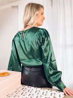 We’re bringing the glam this holiday season with our Emerald Sky Satin Top! Designed in a round neckline and satin jacquard fabric. The puff sleeve with buttoned cuffs make this a stand out piece for any occasion. It’s completed with a relaxed fit making it easy to pair with just about anything. Fit: True to size Fabric: 100% Polyester Lining: Unlined but not sheer Care: Machine wash in cold water and hang dry Melissa is wearing a size Small and her measurements are:Height: 5'0” | Bust: 36” | Waist: 28” | Hips: 37.5" Satin Tops For Fall Party, Chic Puff Sleeve Top With Bishop Sleeves For Party, Fall Party Blouse With Bishop Sleeves, Party Tops With Gathered Balloon Sleeves, Party Tops With Balloon Gathered Sleeves, Satin Puff Sleeve Tops For Night Out, Glamorous Satin Tops For Fall, Fall Party Top With Gathered Sleeves, Party Puff Sleeve Top With Balloon Sleeves