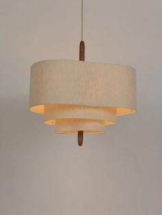 a light fixture hanging from the ceiling with a white shade on it's side