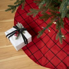 a present wrapped in black and white ribbon sitting on top of a red tablecloth