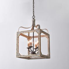 a chandelier hanging from a chain with three candles in it's center