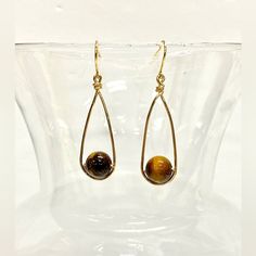 Imagine Wearing These Exquisite Handmade Tiger's Eye Wire-Wrapped Dangle Earrings, Each Bead Lovingly Encased In Shimmering Gold Tone Wire That Dances With Every Movement. The 9mm Genuine Tiger's Eye Beads, With Their Mesmerizing Golden-Brown Hues, Exude A Sense Of Warmth And Depth. The Handcrafted French Hook Ear Wires Ensure A Secure And Comfortable Fit, Allowing You To Wear These Earrings With Confidence All Day Long. Their Minimalist Design Adds A Touch Of Modern Elegance To Any Outfit, Whet Stud Wire Earrings, Brass Wire Jewelry, Diy Wire Wrapped Earrings, Fall Wire Wrapped Jewelry, Teardrop Earrings Gift, Handmade Teardrop Wrap Earrings In Minimalist Style, Handmade Minimalist Teardrop Wrap Earrings, Gold Hand Wrapped Teardrop Earrings, Minimalist Wire Wrapped Beaded Earrings For Gift