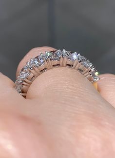 a woman's hand holding a diamond ring in her left hand, with the middle section