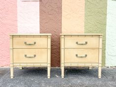 two nightstands side by side in front of a multicolored wall and building