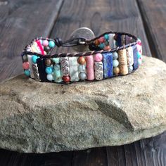 This multi color beaded bracelet for women is stunning and unique. This single wrap bracelet would compliment and outfit you want to wear it with. This bracelet would be a beautiful meaningful gift for your mother on Mother's Day. It will be a gift she can enjoy every day. This leather beaded bracelet is made with a variety of gemstone beads in various sizes and colors. Please choose the size you would like at check out. Artisan Beaded Multicolor Wrap Bracelet, Artisan Multicolor Beaded Wrap Bracelet, Adjustable Multicolor Artisan Wrap Bracelet, Multicolor Beaded Wrap Bracelet For Friendship, Multicolor Beaded Friendship Wrap Bracelet, Artisan Multicolor Wrap Bracelet For Festival, Multicolor Hand Wrapped Crystal Bracelet, Hand Wrapped Multicolor Crystal Bracelet, Adjustable Colorful Beads Wrap Bracelet