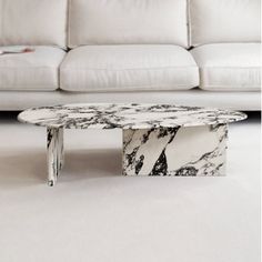 a marble coffee table sitting in front of a white couch