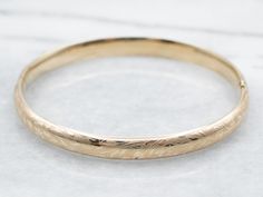 The details on this vintage 14-karat gold bangle are simply stunning! Intricate scrolling botanical designs are engraved in warm yellow gold, covering the entire bracelet. Beautiful on its own or layered with other bracelets this piece is perfect for day or evening wear.Metal: 14K Yellow GoldWidth: 6.3 mmInside Circumference: 6 1/2 InchesMarks: "JW 14K" Stamped on the inside band Alysanne Targaryen, Bangle Stacking, Yellow Gold Bangle, Warm Yellow, Gold Bangle Bracelet, Gold Bangle, Hinged Bangle, Vintage Botanical, Bracelet Stack