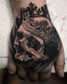 a hand with a skull and crown on it