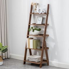 a tall wooden shelf with books on it next to a potted plant and window