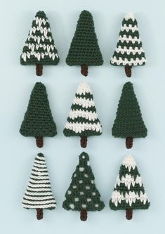 crocheted christmas trees arranged in rows on a blue background with white and green stripes