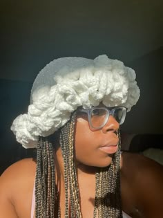 a woman with long dreadlocks wearing a white hat and eyeglasses on her head