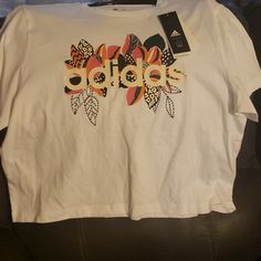 Nwt Ladies Sz Large Tshirt With Flower Design Adidas T-shirt For Spring Streetwear, White Cropped T-shirt With Logo Print For Spring, Spring White Cropped T-shirt With Logo, Trendy Adidas T-shirt With Letter Print, Trendy Adidas T-shirt For Spring, Spring Sporty Graphic Print T-shirt, Sporty Graphic Print T-shirt For Spring, Sporty Spring Graphic Print T-shirt, Adidas Casual T-shirt With Graphic Print