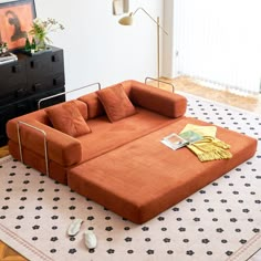 an orange couch sitting on top of a white rug