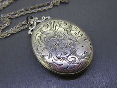 Beautiful antique sterling silver oval locket that comes with a vintage (not original to the locket but still vintage) 18" sterling silver chain.  Locket opens and closes great!  Light age related wear and patina on the locket, some small dings on the back.  Has the original photos inside but no frames/covers.  Visit Ribbons Edge for more great pieces of vintage and antique jewelry!  All items added to your cart at Ribbons Edge will automatically combine shipping. To stay up to date with my newe Vintage Etched Oval Pendant Locket Necklace, Vintage Engraved Oval Pendant Locket Necklace, Vintage Oval Engraved Locket Necklace, Vintage Engraved Oval Locket Necklace, Antique Etched Oval Locket Necklace, Antique Sterling Silver Locket Necklace With Oval Pendant, Ornate Oval Locket Necklace From Vintage Collection, Antique Silver Necklace With Vintage Charm, Vintage Silver Oval Pendant Locket Necklace