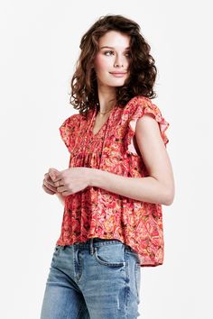 image of a female model wearing a VAYDA SMOCKED YOKE SHIRT AUTUMN PAISLEY DEAR JOHN DENIM Casual V-neck Top With Smocked Back, Chic V-neck Smocked Top For Vacation, V-neck Smocked Top With Smocked Bodice For Vacation, Summer V-neck Top With Smocked Bodice, Bohemian V-neck Top With Smocked Back, Bohemian V-neck Tops With Smocked Back, Vacation Tops With Smocked Bodice And Short Sleeves, Flowy Blouse With Smocked Back, Casual Blouse With Flutter Sleeves And Smocked Back