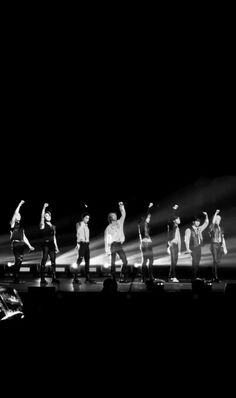 a group of people standing on top of a stage with their arms in the air