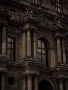 an old building with many windows and statues on it