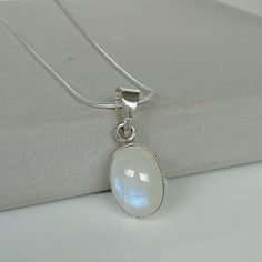 "\" Moonstone Is a stone for new beginnings, Inner growth and strength\" ▪︎ An oval moonstone. This stone is mounted on a simple sterling silver pendant frame. ▪︎ Size:- 17 x 13mm.   ▪︎ This multi purpose pendant can be used as a charm in necklaces, bracelets, anklets, key chains, zip pullers etc. ▪︎ This pendant is handmade with hypoallergenic sterling silver. Most of my pieces are marked with a 925 silver stamp. ▪︎ Please note: This listing is for ONE pendant  and comes WITHOUT the chain, however, you can add a snake chain in the required length while making your selection. You can also opt to choose other kinds of neck chains or bracelet chains from my shop  by visiting the links below. ▪︎ I can send this piece in a gift box or  include a gift message from you if required. ▪︎▪︎ Please r Oval Moon Phase Necklace As A Gift, Moon Phase Oval Necklace For Gifts, Oval Moon Phase Necklace For Gift, Oval Moon Phase Necklace Gift, Mystical White Moonstone Necklaces, Mystical White Moonstone Necklace, Spiritual Moonstone Birthstone Necklace, White Moonstone Moon Phase Necklace, White Mystical Gemstone Necklace