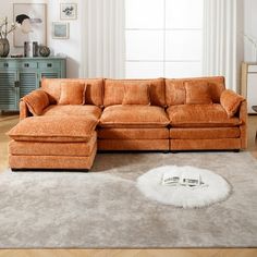 an orange sectional sofa in a living room with white rug and large window behind it